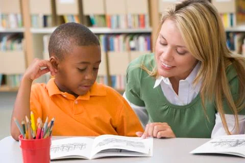 Student in class reading with teacher Stock Photos
