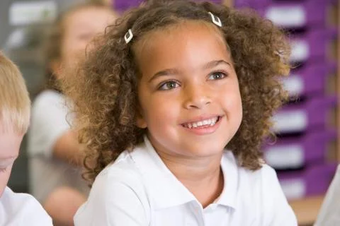 Student in class sitting on floor with students in background (selective focus) Stock Photos
