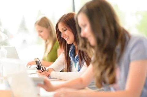 Student in classroom using phone write message Stock Photos