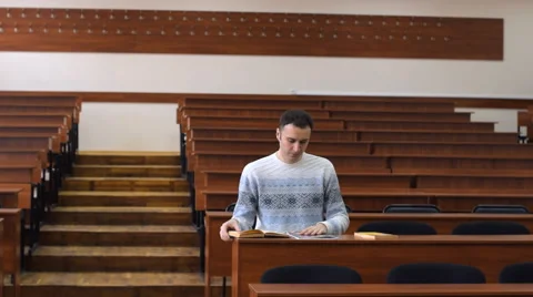 Student closes the books, gets up from his desk and goes out of the lecture hall Stock Footage 63149769