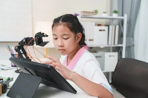 A student coding a DIY robot with a touch screen. Modern tech education. Stock Photos