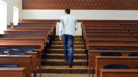 The student comes into the lecture hall and sits down at the desk Stock Footage 62595095