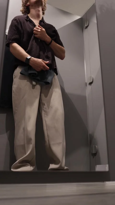 Student compares clothes on hangers and decides which items to try on Stock Footage 344856030