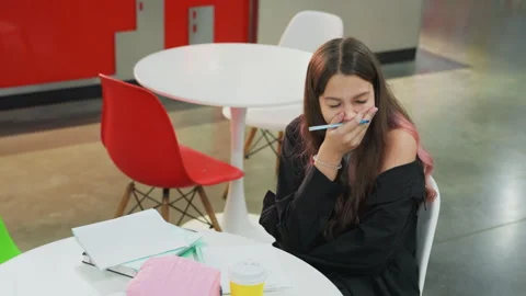 Student concentrates while writing in notebook. Person carefully writes in Stock Footage 331360948