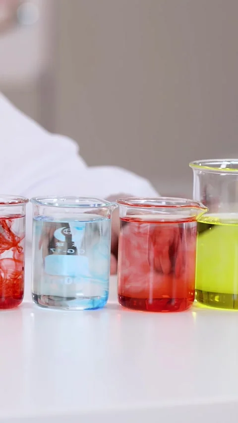 Student Conducting Science Experiment with Colorful Liquids in Glass Beakers Stock Footage 342575088
