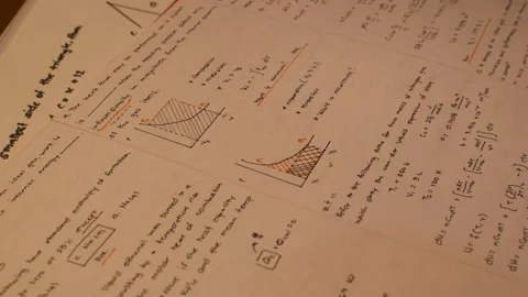 A student deeply studying his complicated notes with diagrams and graphs, Stock Footage 101365892
