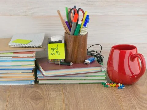 Student desktop, stack books, accessories, stationery, red mug, flash drives, Stock Photos