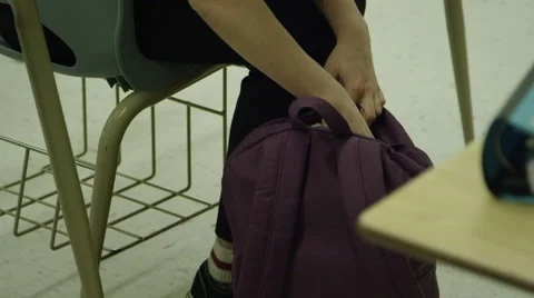 Student digging through school bag in the classroom Stock Footage 61356354