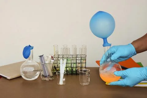 Student do science experiment, lab lesson, transparent bottles with inflated bal Stock Photos