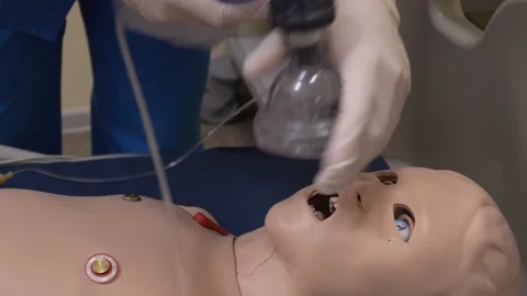 Student doctor using oxygen mask on simulation baby doll, close-up Video stock 142606156