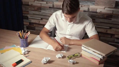 Student doing homework. Boy tears out a sheet of paper and throws it away Stock Footage 111700722