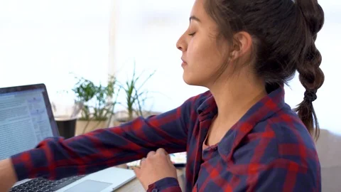 Student doing homework on computer and writing in notebook Stock Footage 126210889