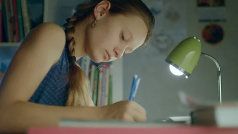 A student doing lessons at home till night Stock Footage 82424073