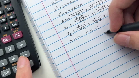 A student doing math in a notebook using a scientific calculator. Stock Footage 310407307