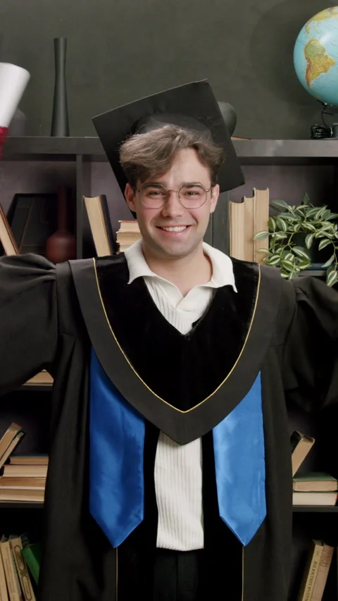 Student dressed in black robe with cap on head joyfully and proudly raises hands Stock Footage 316606225