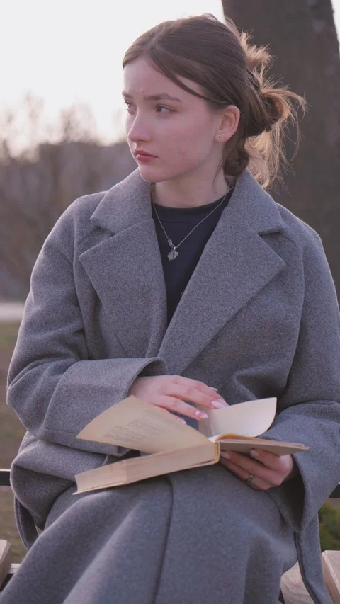 Student drinking coffee and reading a book on a bench Vídeo Stock 309782183