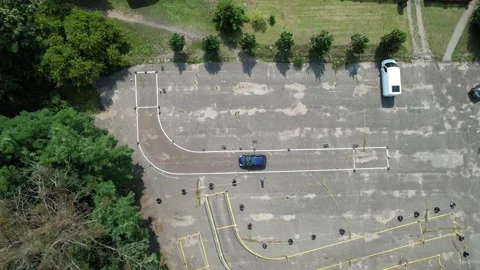 Student driver practicing reverse parking maneuver at driving school test track Stockbeeldmateriaal 347864990