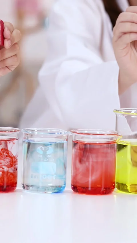 Student Dropping Red Liquid into Beakers During Science Experiment Stock Footage 342087085