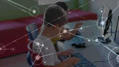 Student duo typing at computer desks and initiating network nodes showing growth Stock Footage 312280380