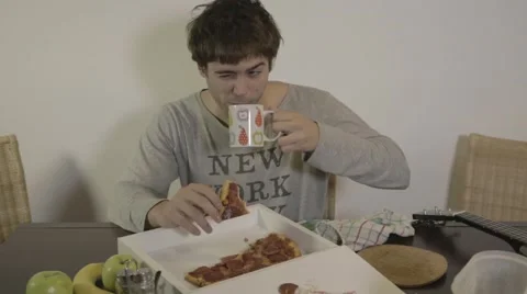 Student eating pizza for breakfast Stock Footage 46263377