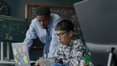 Student Engaged in Robotics and Coding Lesson with Teachers Guidance Stock Footage 284437698