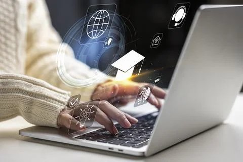 A student engages with online learning, using a laptop surrounded by digita.. Stock Photos