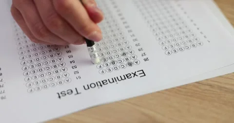 Student erases wrong answer on exam form at desk in classroom Stock Footage 267092021
