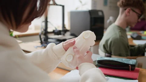 Student Examining 3D-Printed Car Model After Hands-On Session in Class Stock Footage 335697524