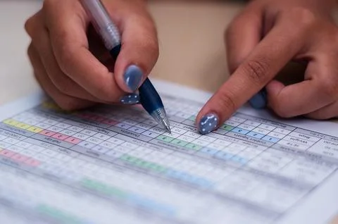 Student examining data with a pen on a document Stock Photos
