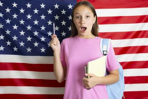 Student exchange program in the USA, girl studying in front of American flag Stock-Fotos