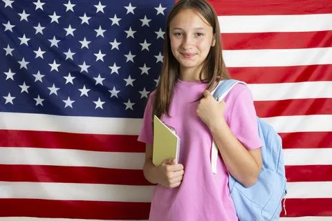 Student exchange program in the USA, girl studying in front of American flag Stock-Fotos