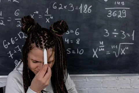 A student is facing challenges while working on math problems displayed on a Stock Photos