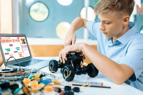 Student fixing robotics vehicle learn technology in STEM class. Edification. 库存照片