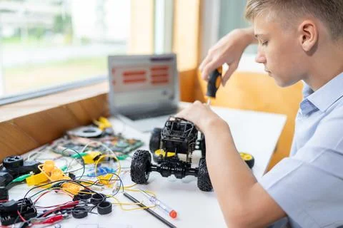 Student fixing robotics vehicle learn technology in STEM class. Edification. Stockfoto's