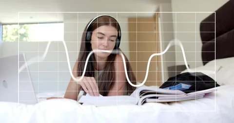 Student flipping pages and underlining notes beside laptop activating pulsing Stock Footage 316964830