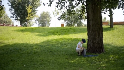 Student girl with backpack goes through park., summer day in city park Stock Footage