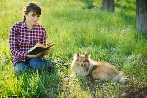 Student girl learning in nature with dog Stock Photos
