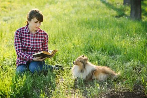 Student girl learning in nature with dog Stock Photos