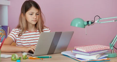 Student girl using laptop when doing homework, sitting at the desk and smiling Stock Footage 96202845