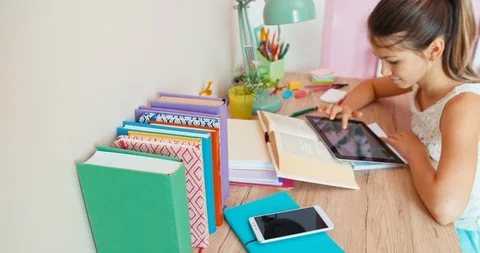 Student girl using tablet pc when doing homework Video stock 96049802