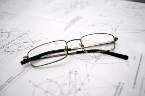 Student glasses left on plans for construction Stock Photos