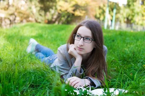 Student with glasses lying on grass Stock Photos