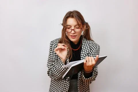 A student in glasses makes a note in a notebook. The process of studying at.. Foto stock