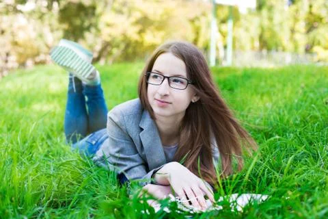 Student with glasses thinking on grass Stock Photos