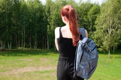 Student going with her backpack, forest on background Stock Photos