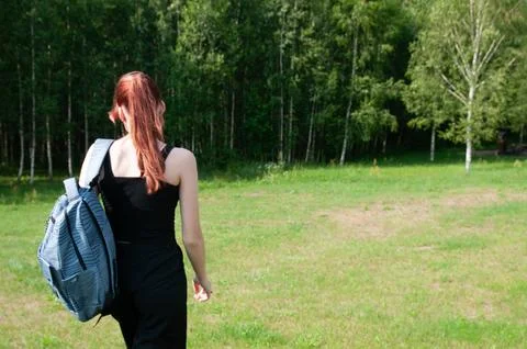 Student going with her backpack, forest on background Stock-Fotos