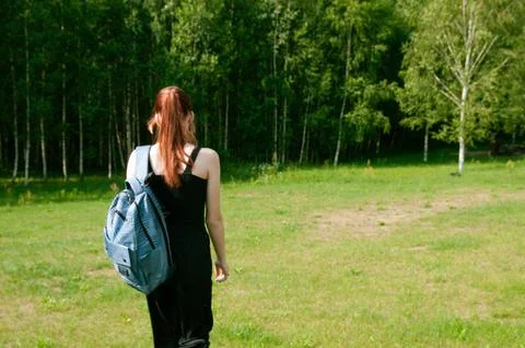 Student going with her backpack, forest on background Stock Photos