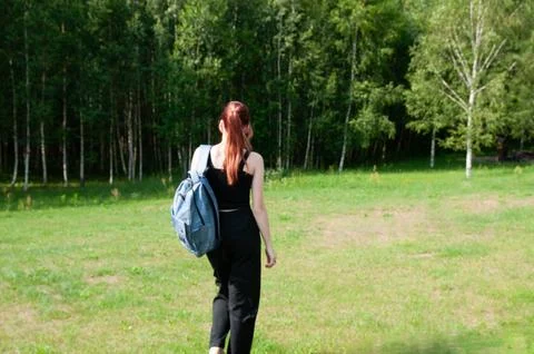 Student going with her backpack, forest on background Foto stock