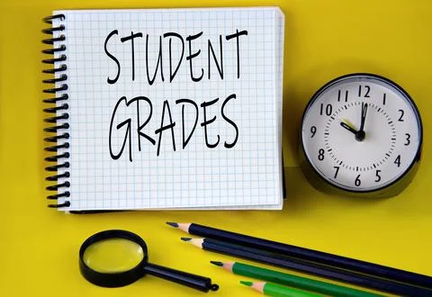 STUDENT GRADES - words in a white notebook with an alarm clock, pencils and m Stock Photos