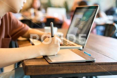 Student graphic design hand drawing on pen mouse pad with laptop Stock Photos
